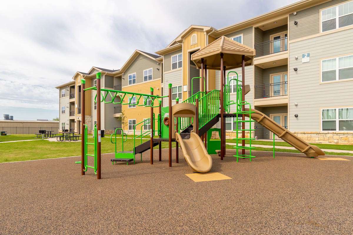 Playground and building exterior at Menchaca Commons